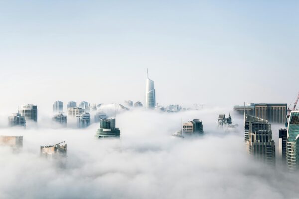 A stunning view of Dubai skyscrapers emerging through a blanket of fog, showcasing modern architecture.